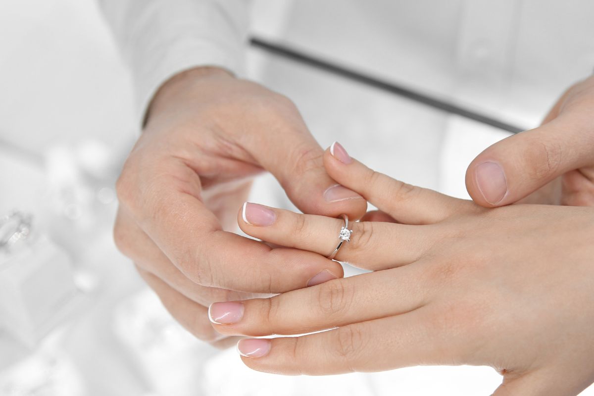 A girl trying her wedding ring in her right hand