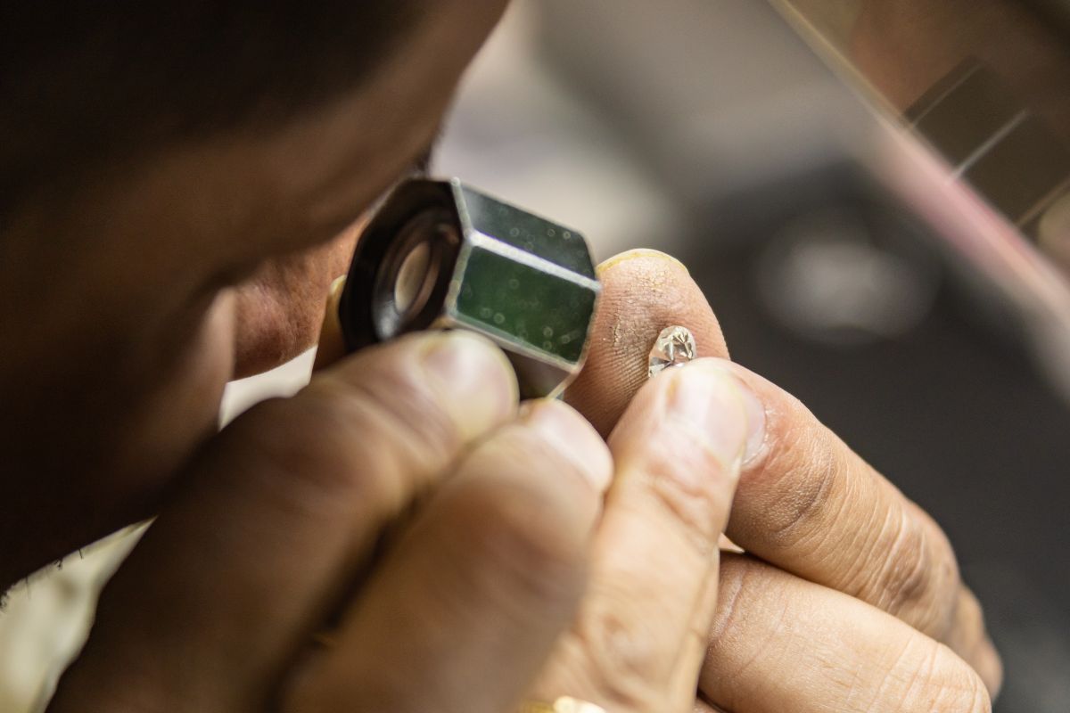 A guy checking a quality of cushioned cut diamond