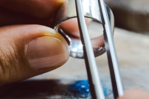 A guy cleaning a platinum ring