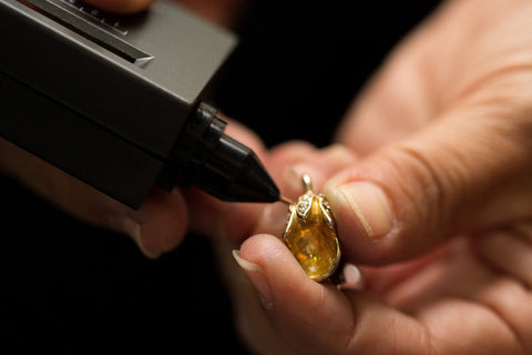 A guy using diamond tester on a diamond