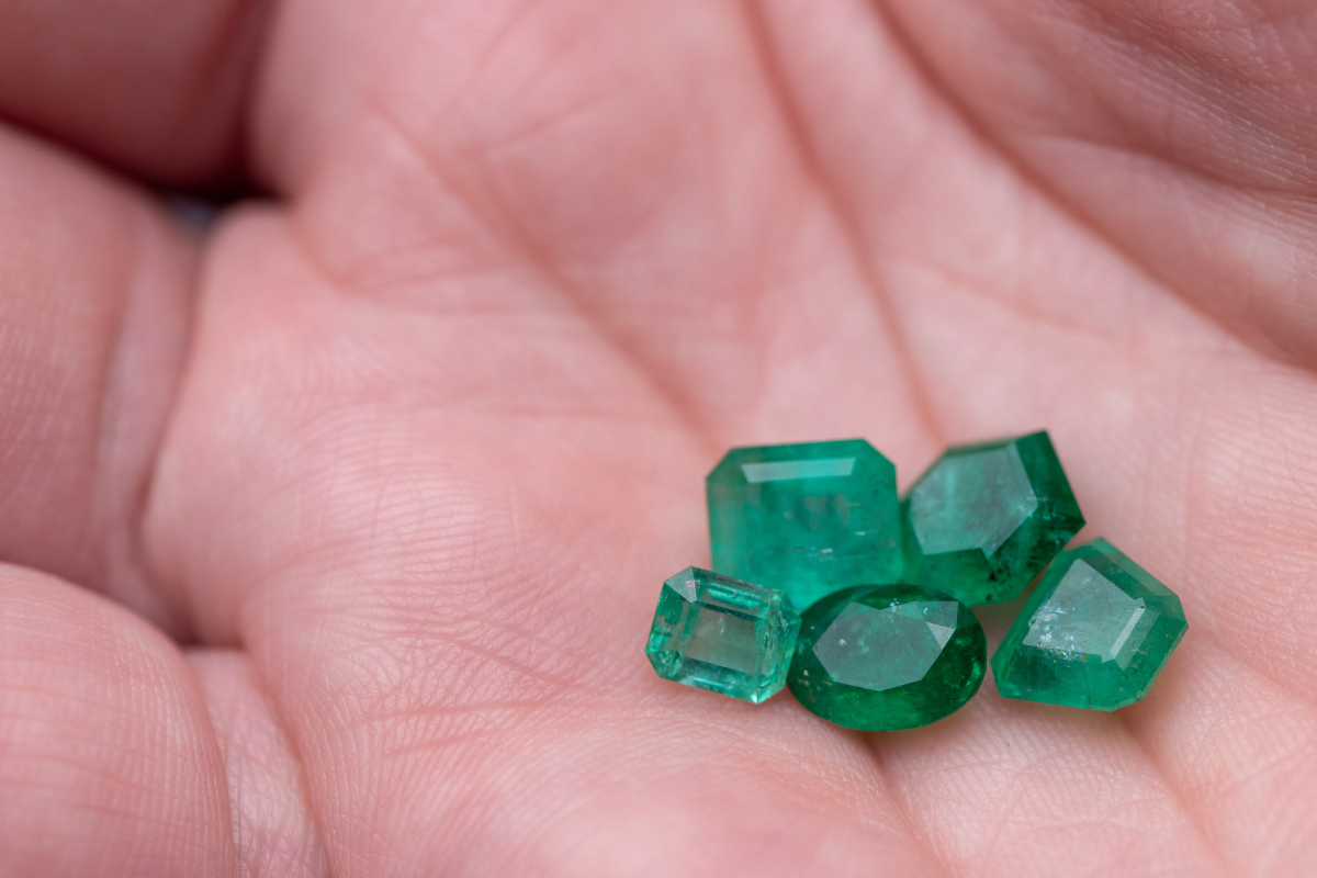 A hand having Emerald and Green Sapphire diamonds