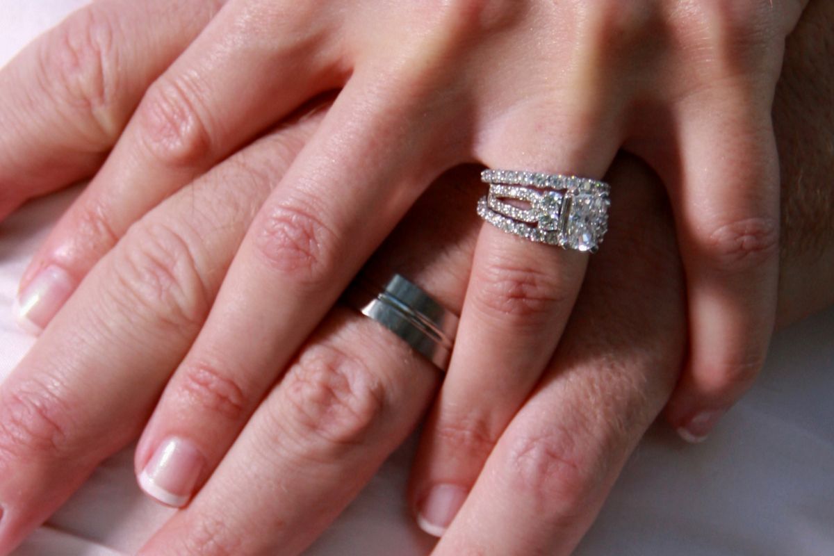 A husband wearing a tungsten ring and his wife wearing a diamond ring