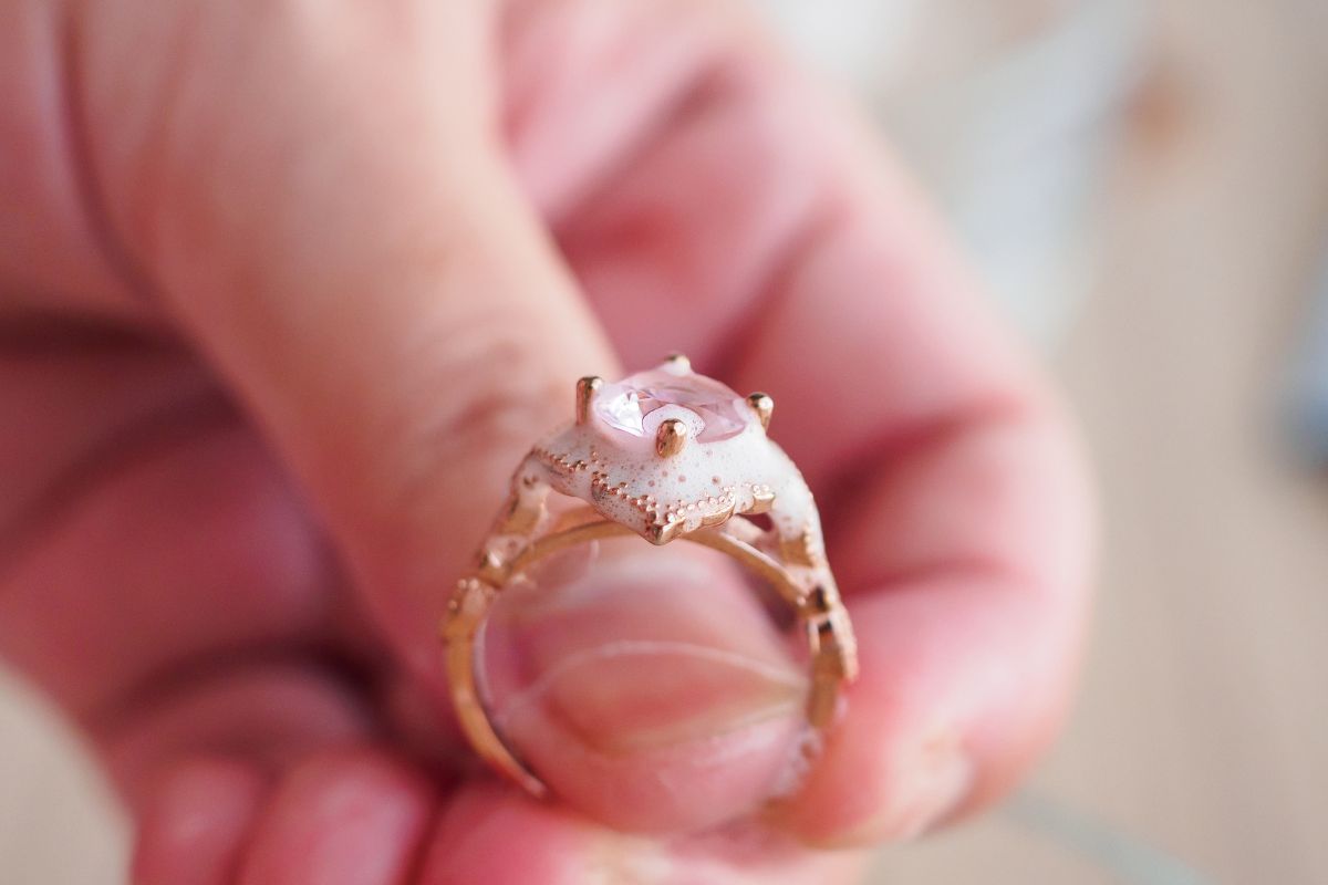 A lady applied soap on the diamond ring to clean it.