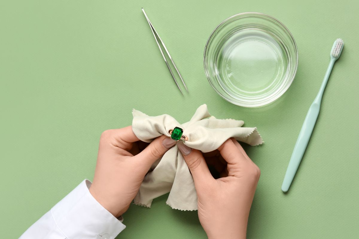 A lady cleaning her emerald ring.