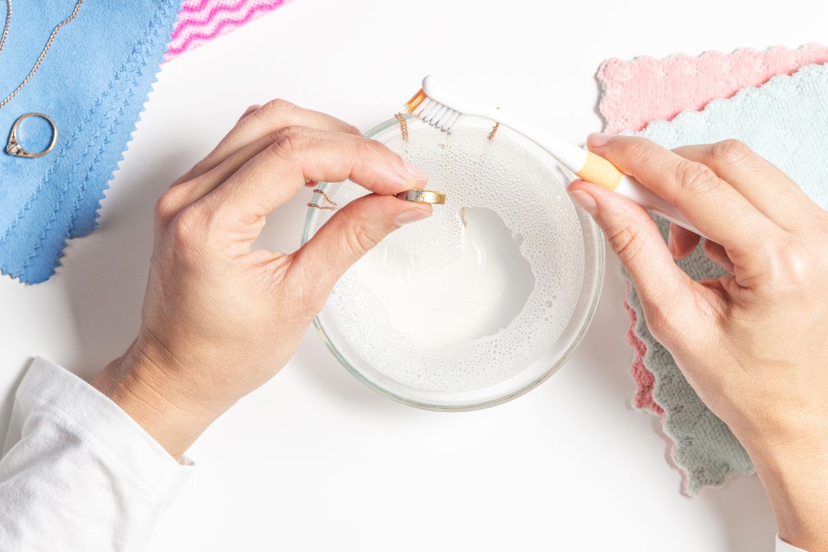 A lady cleaning her gold jewelry items with mild soap water for optimum brilliance.