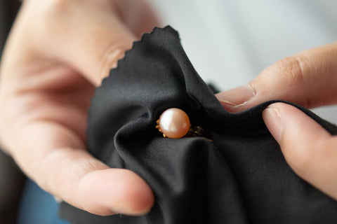 A lady cleaning her pearl jewelry