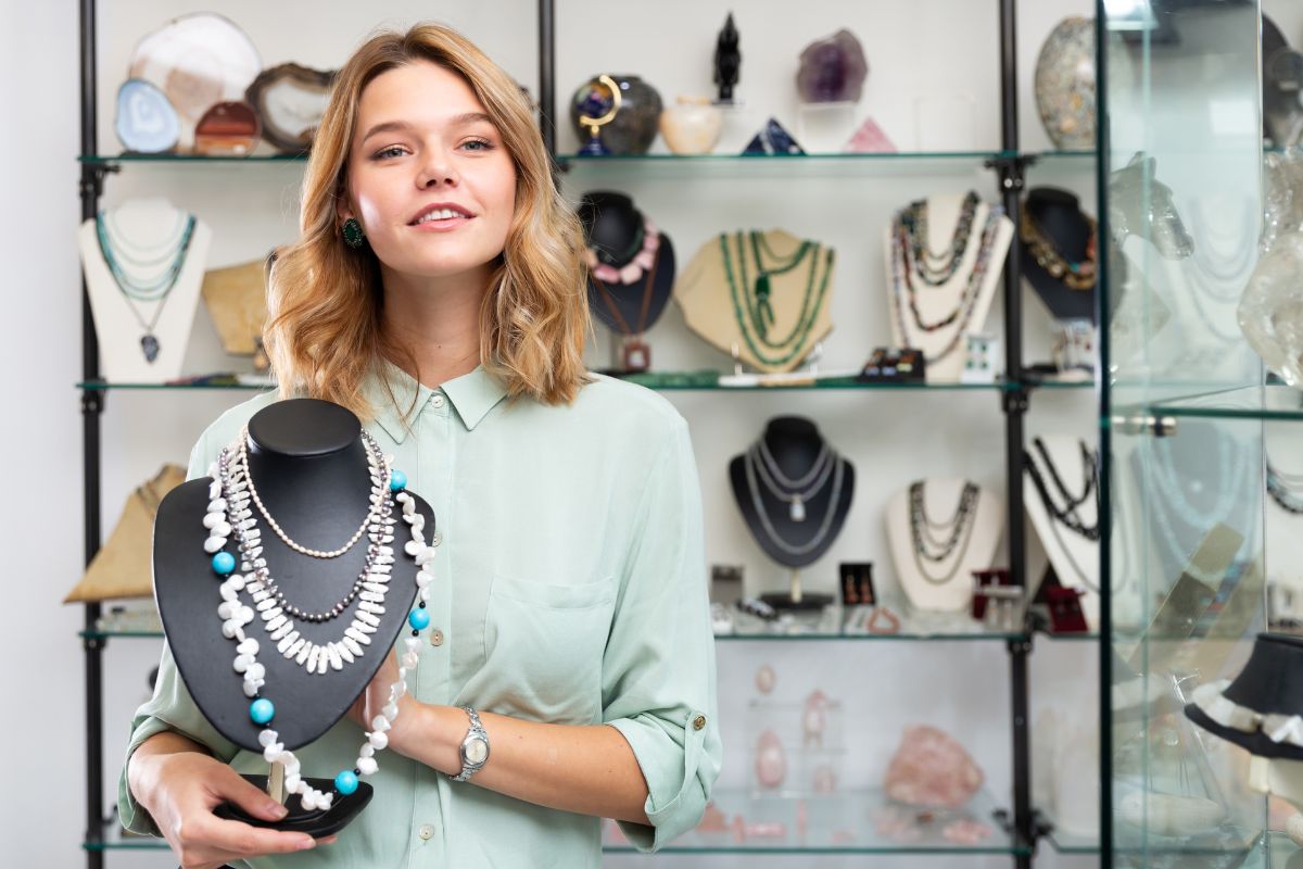 A lady holding multiple pearl necklaces