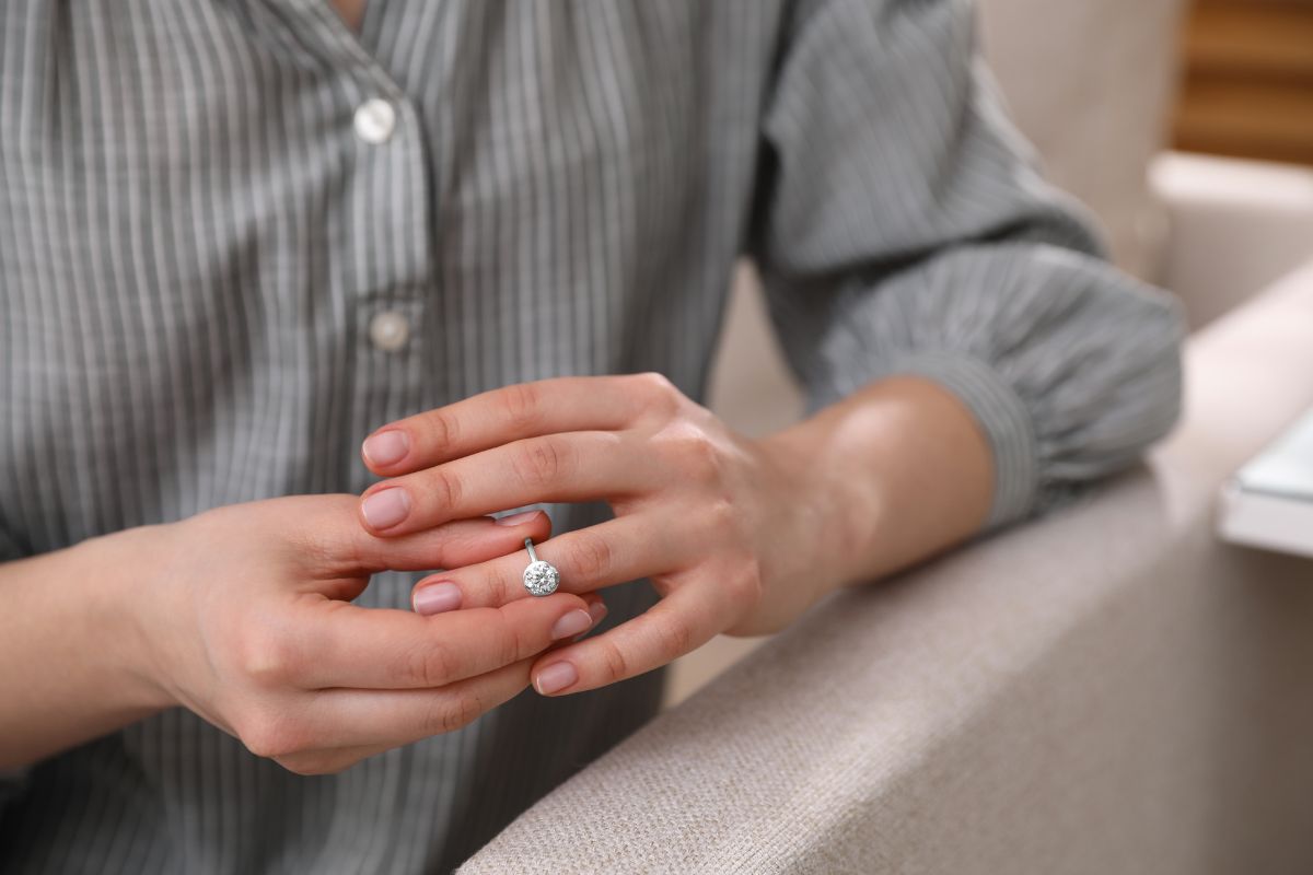 A lady removing her diamond ring softly for optimum care.