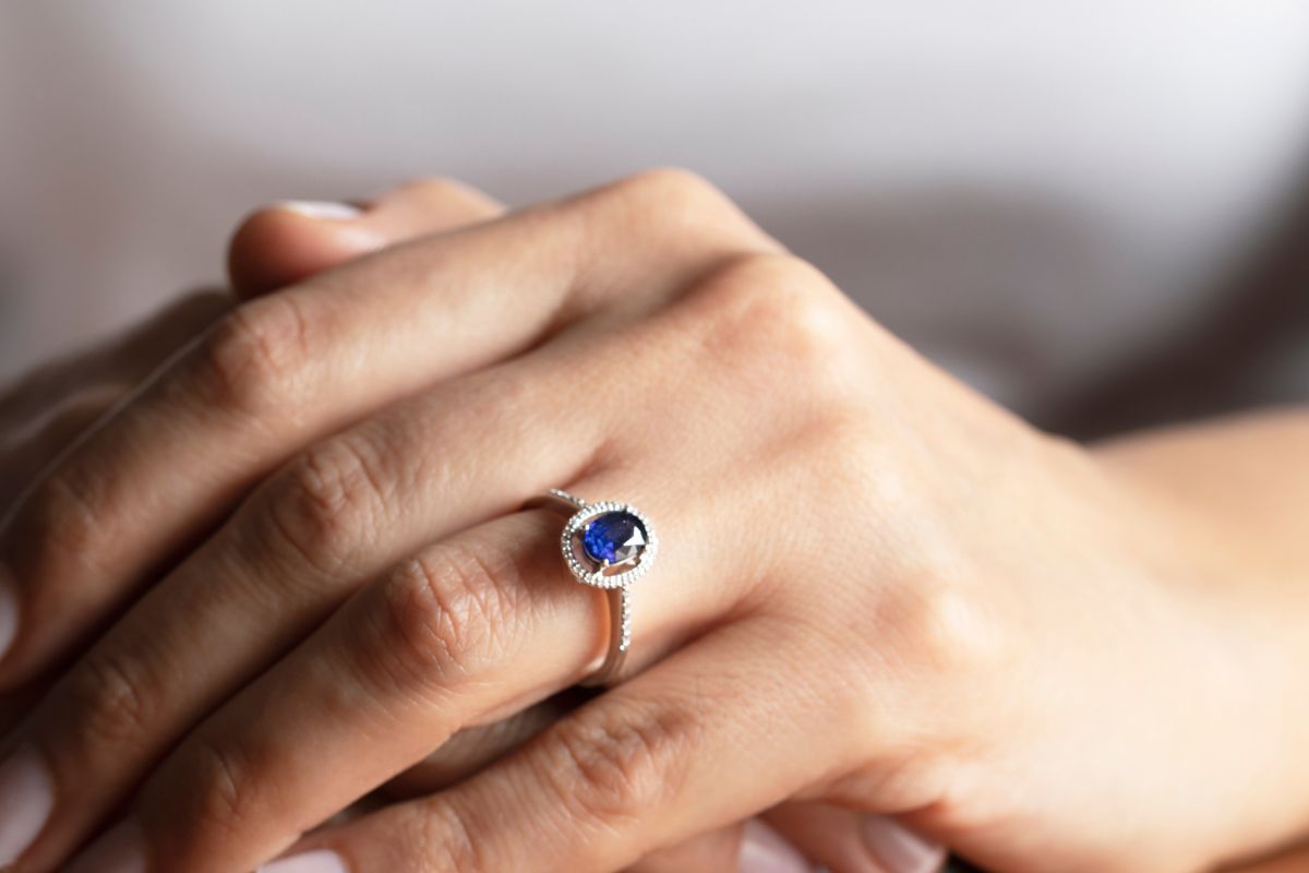 A lady wearing a beautiful sapphire ring on her left hand