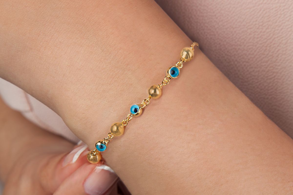 A lady wearing evil eye bracelet on her left hand.