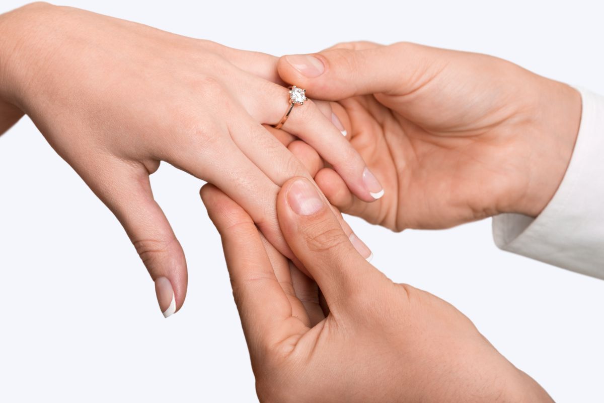 A man placing an engagement ring on a woman's hand