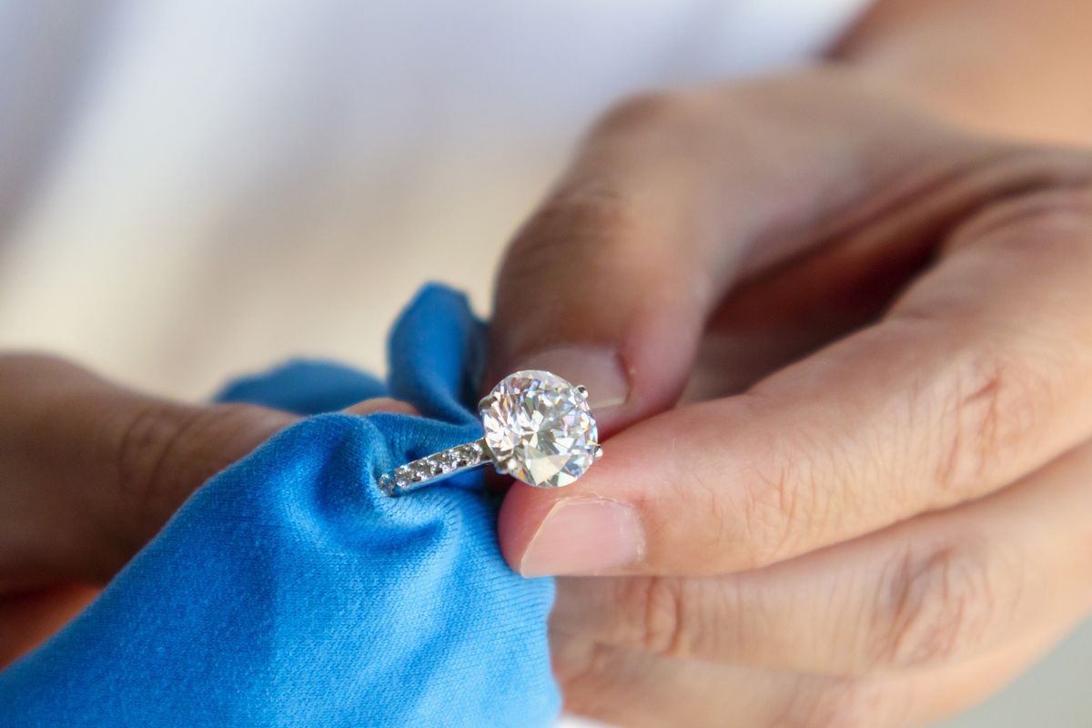 A person handling a diamond engagement ring with care post purchase