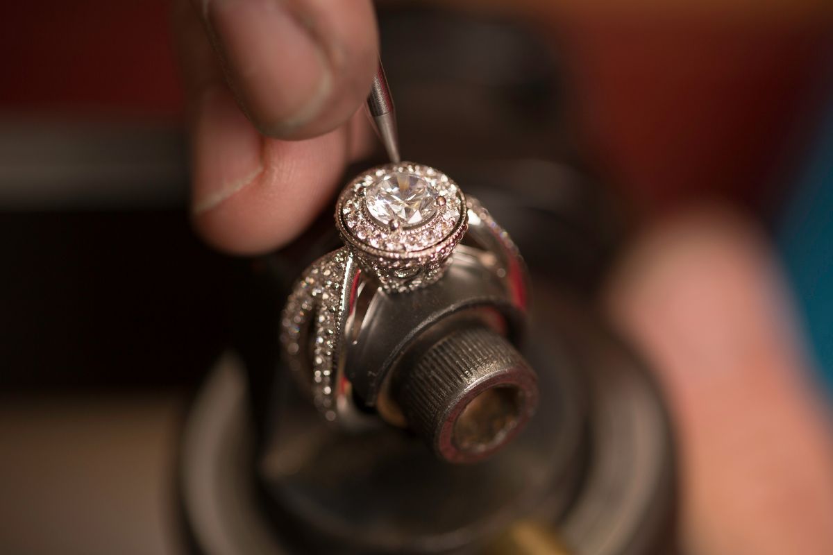 A professional repairing diamond ring after a small diamond detached from the ring