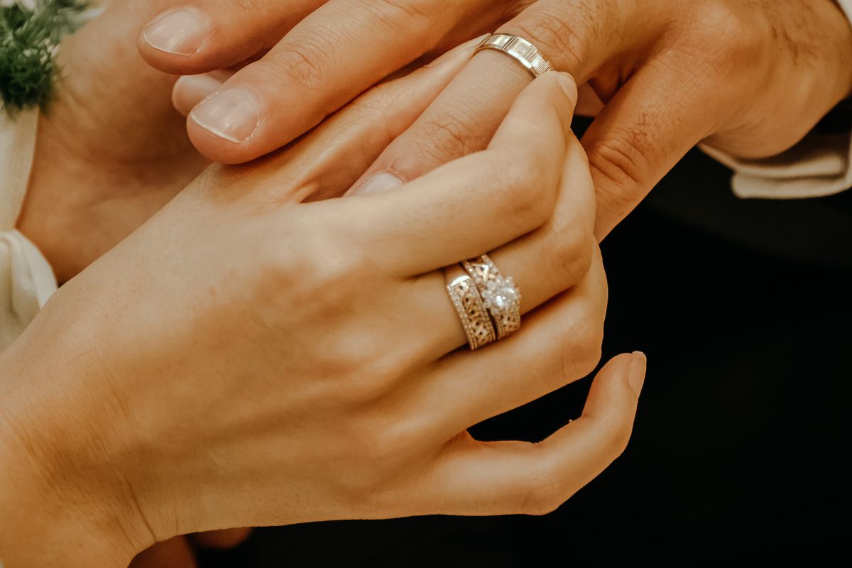 A woman wearing wedding ring and wedding band in her right finger