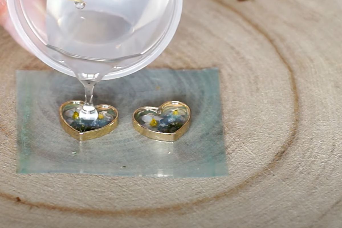 A women creating jewelry with the help of uv resin mixture.