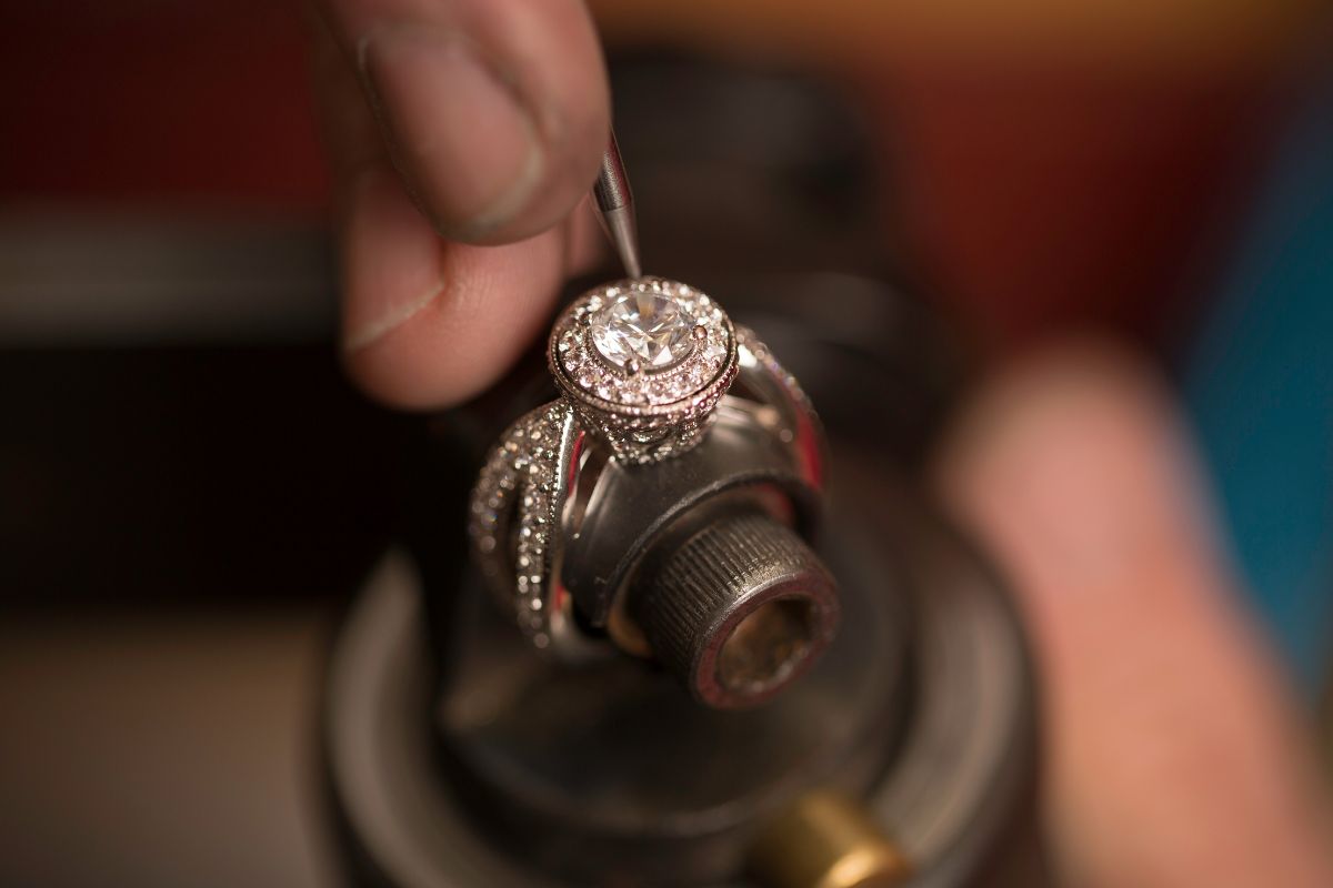 An expert crafting milgrain diamond ring.