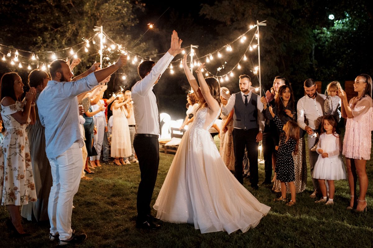 Bride and groom are dancing among loved ones at their wedding reception