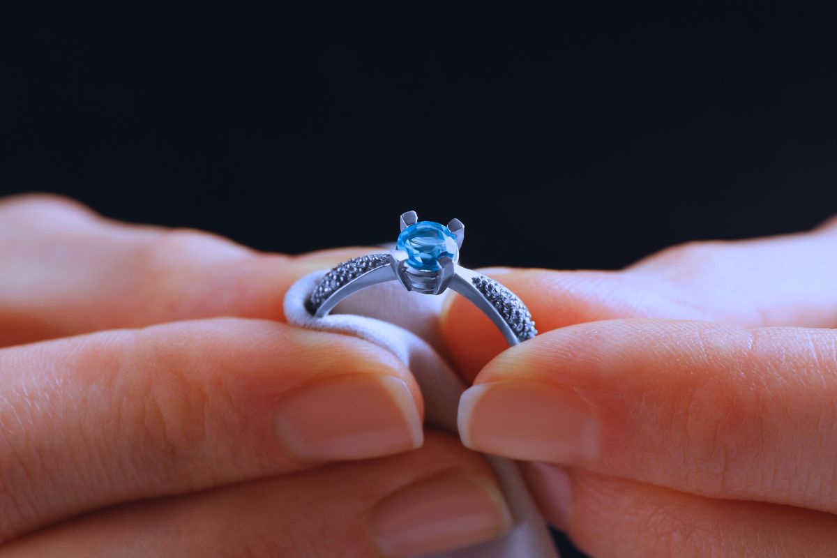 Cleaning a sapphire ring with soft cloth.