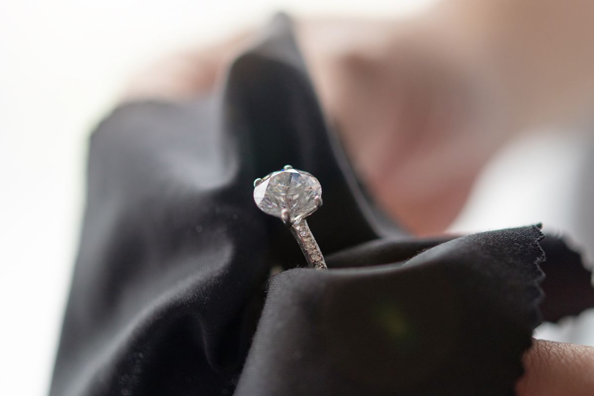 Cleaning diamond ring with soft cloth.