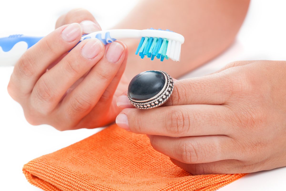 Cleaning opal ring with soft brush and cloth.