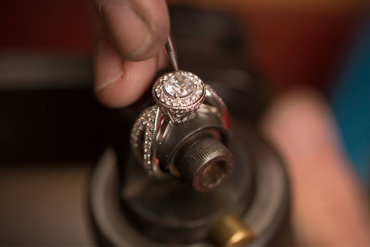 Person crafting diamond ring with professional tools.