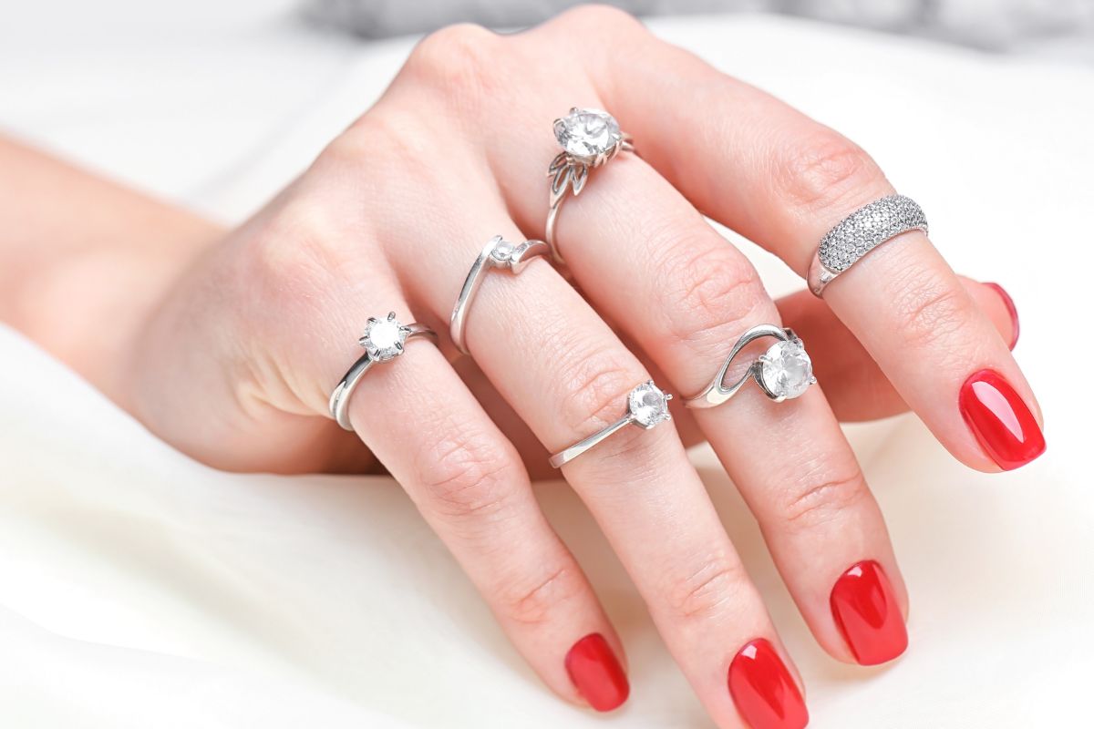 Right hand of a woman wearing a multiple diamond rings