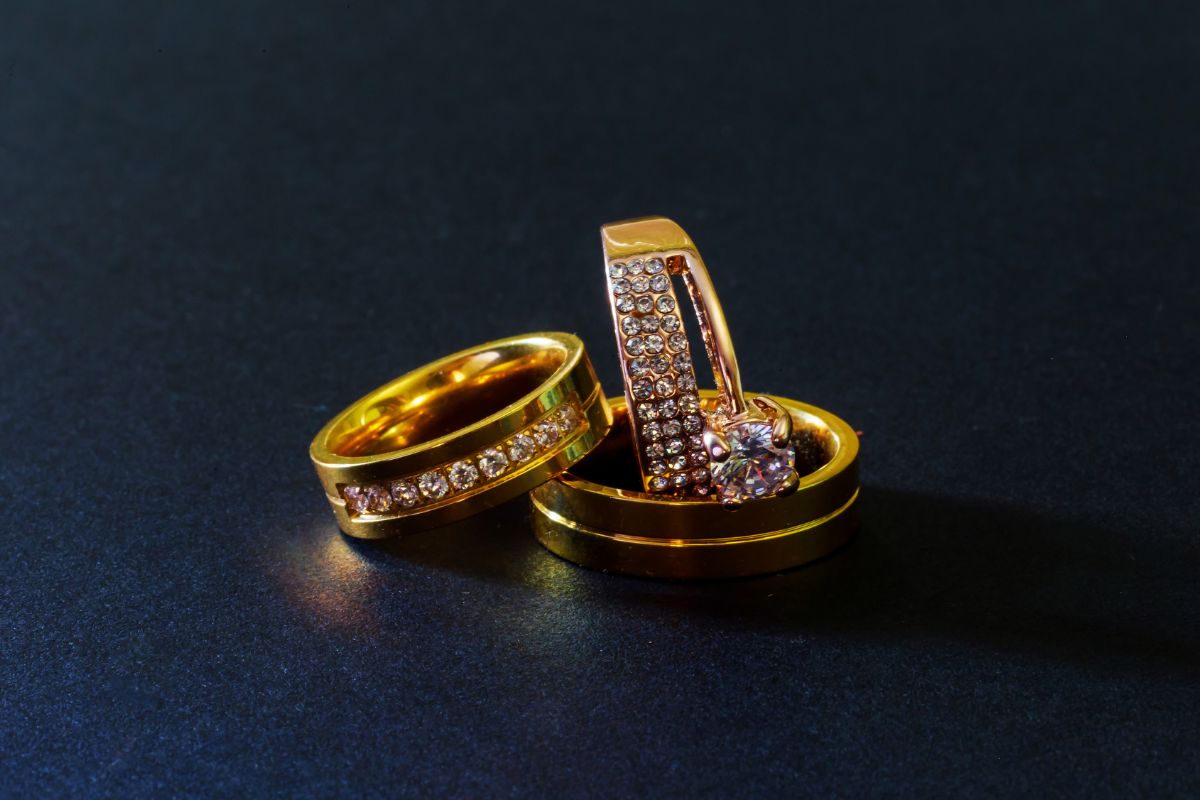 Three beautiful differently styled 14k gold rings kept with each other.