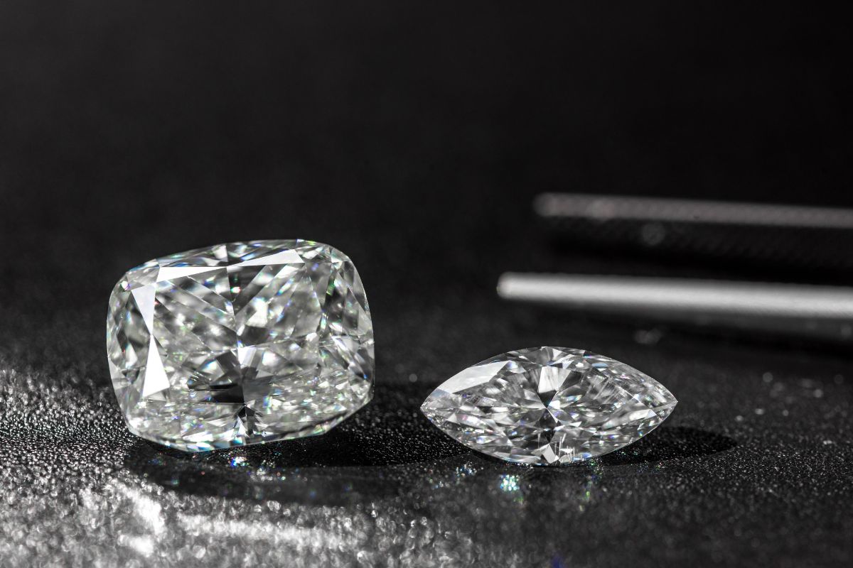 Two diamond kept together with a pincer in the background.