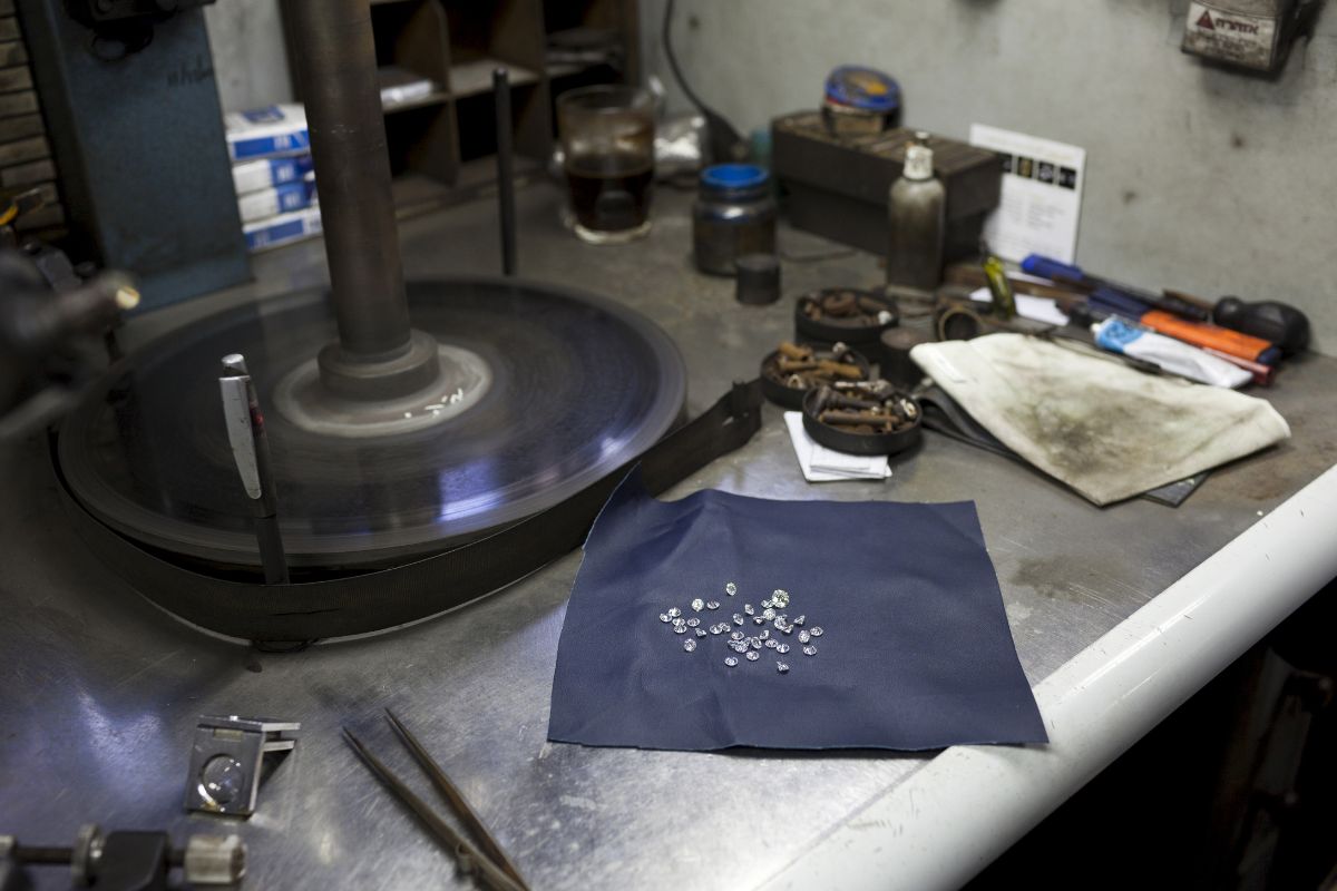 Various diamonds being grinded on the grinding wheel by the expert.