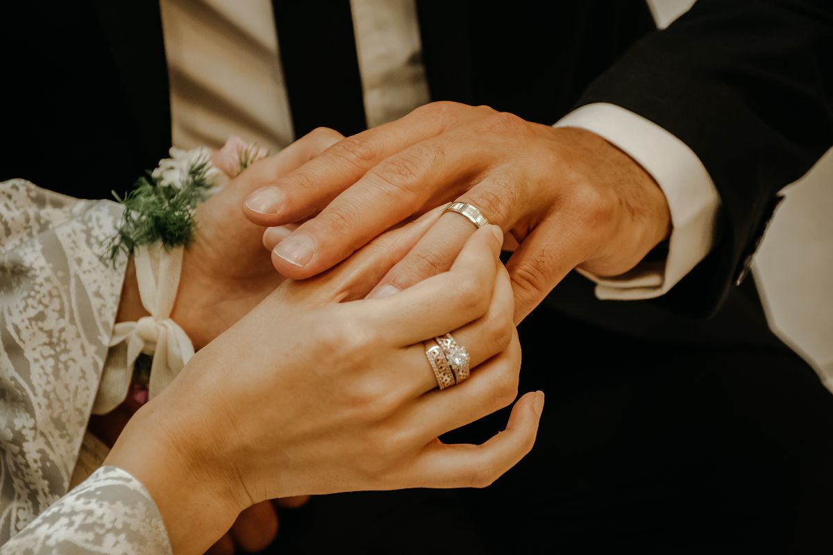 Woman putting wedding ring on man's finger