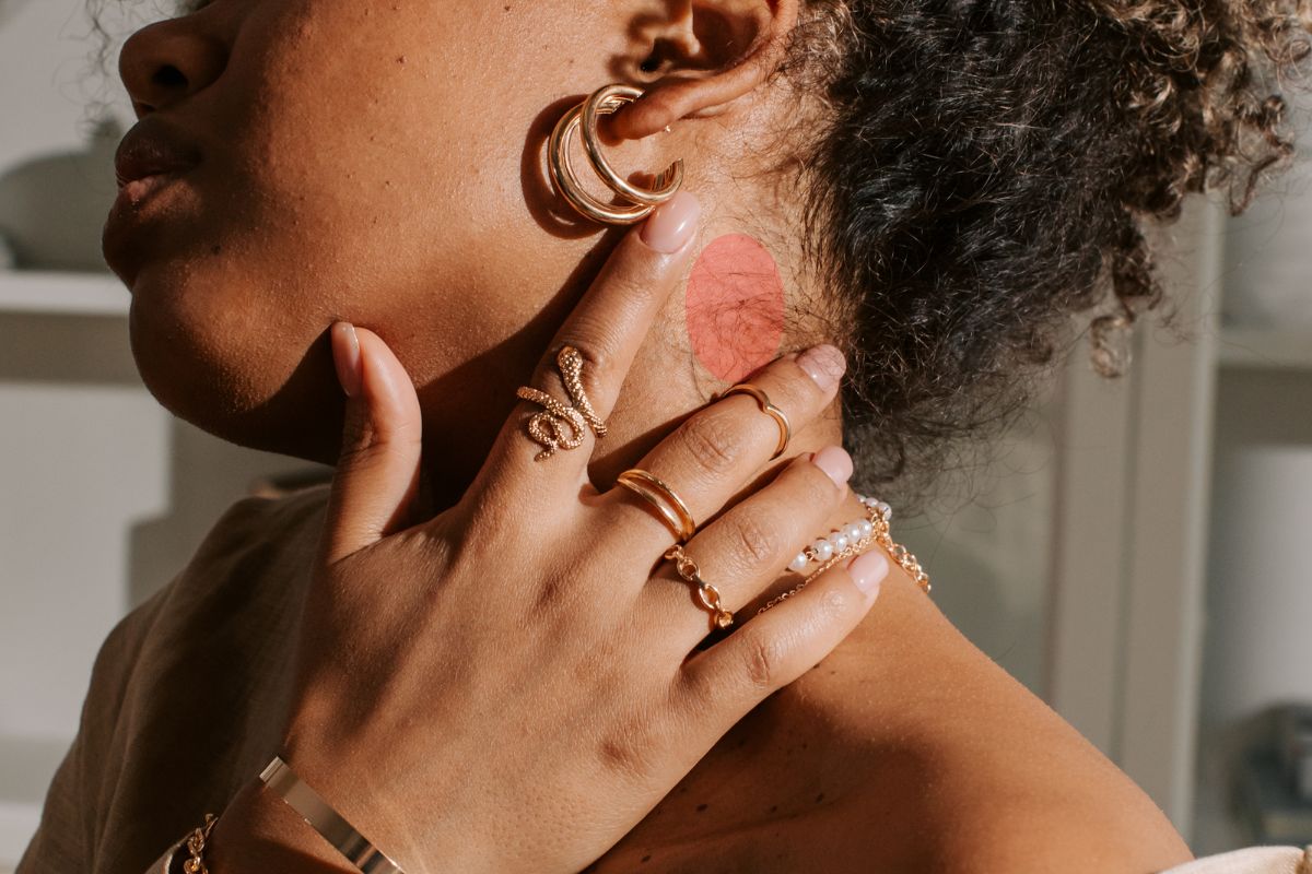 Woman showing allergic reactions to wearing gold jewelry