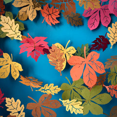 Paper Fall leaves in reds, oranges, yellows and browns against a blue background.
