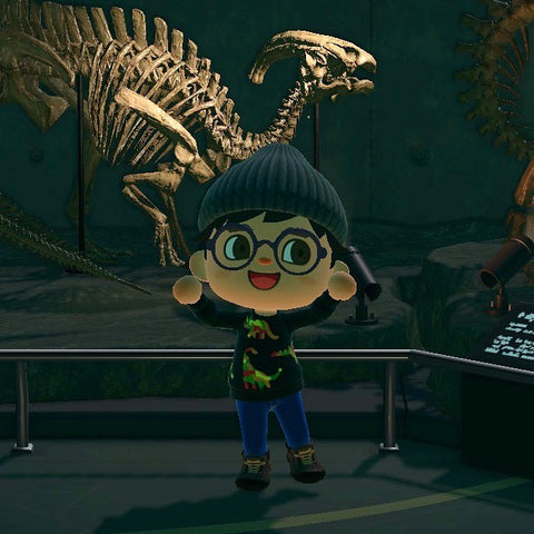 Photo taken from in game. Animal Crossing character is stood in a museum in front of a dinosaur exhibit wearing the rainbow dino jumper they designed in game.