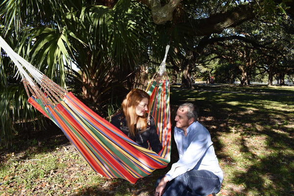A couple enjoying a hammock hung between two trees