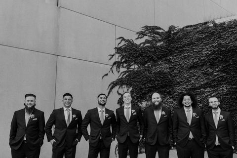 Black and white photo of men, smiling, in bridal party.