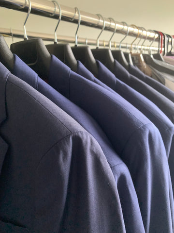 Row of men's suits on rack