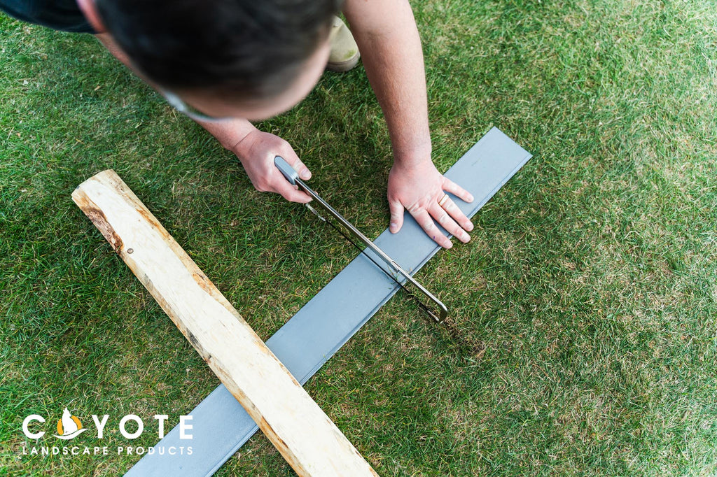 Using a hack saw to score an edge for a corner on landscape edging