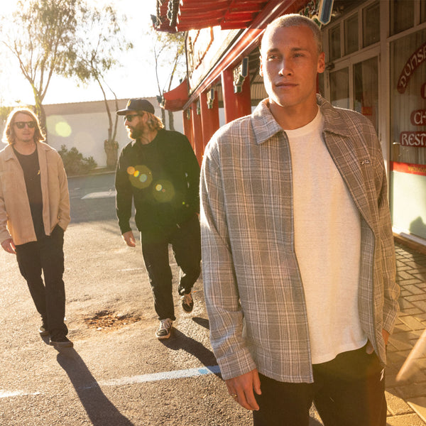 Team Riders Letty Mortensen, Wade Carmichal and Ollie Henry walking in carpark wearing Rusty. Pictured is the Woodchuck Woven Plaid Zip Up Jacket.