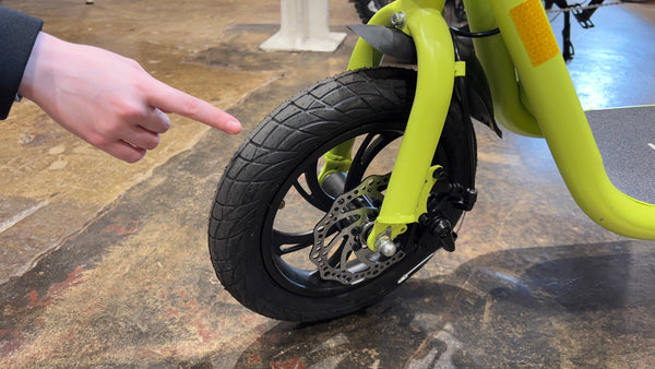 Reviewer points at tyres on Windgoo B9 electric scooter