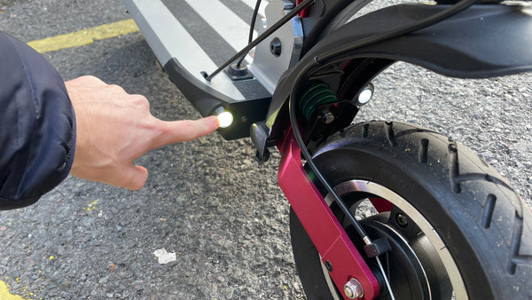 Reviewer point at front lights of Inokim Quick 4 Super electric scooter