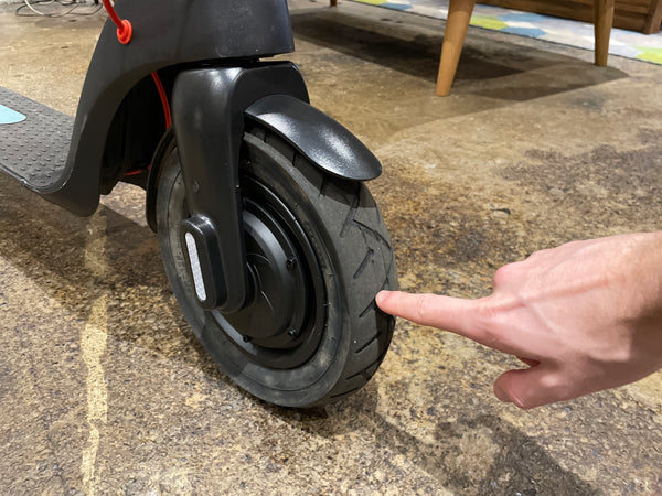Reviewer points at tyres on E-Dash LE1 electric scooter