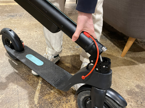 Reviewer folding the E-Dash LE1 electric scooter