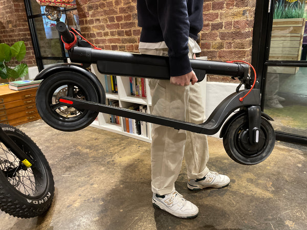 Reviewer carrying E-Dash LE1 electric scooter