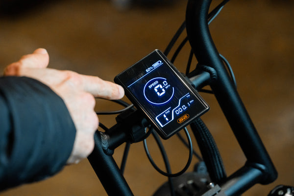 Reviewer pointing at display on Synch Long Tail Monkey electric bike