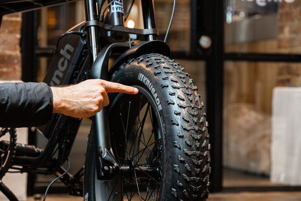 Reviewer pointing at tyres on Synch Long Tail Monkey electric bike