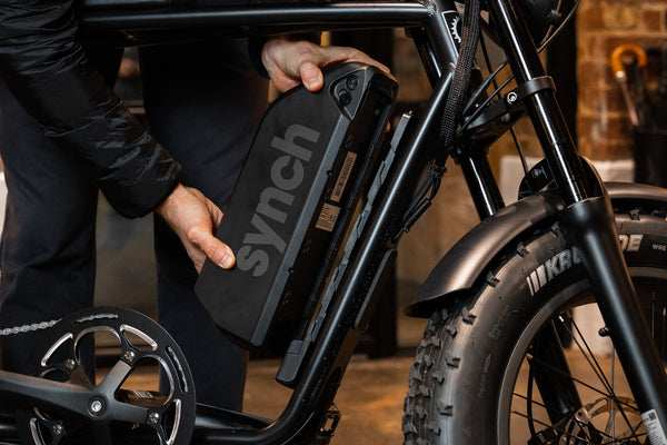 Reviewer removing battery from Synch Long Tail Monkey electric bike