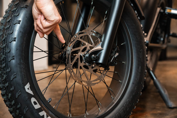 Reviewer pointing at brakes on Synch Long Tail Monkey electric bike