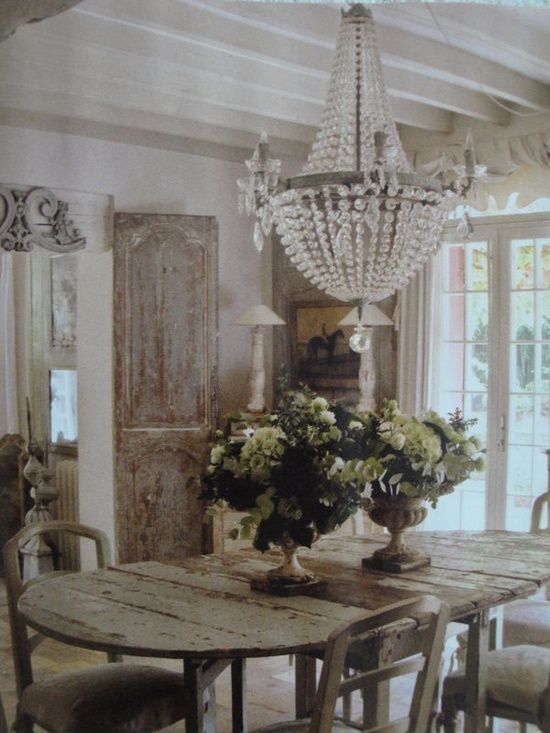 A heavily distressed dining room table serves as a rustic French country focal point.