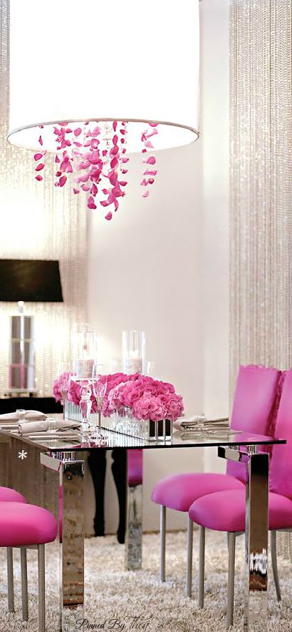 Use a pop of color on a white palette, like these hot pink dining chairs and chrome table. Love the chandelier's pink "crystals" and the drum shade, which is bright yet soft lighting.: 