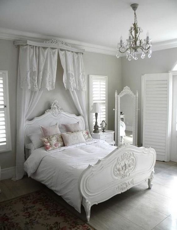 white shabby chic bedroom with crystal chandelier.